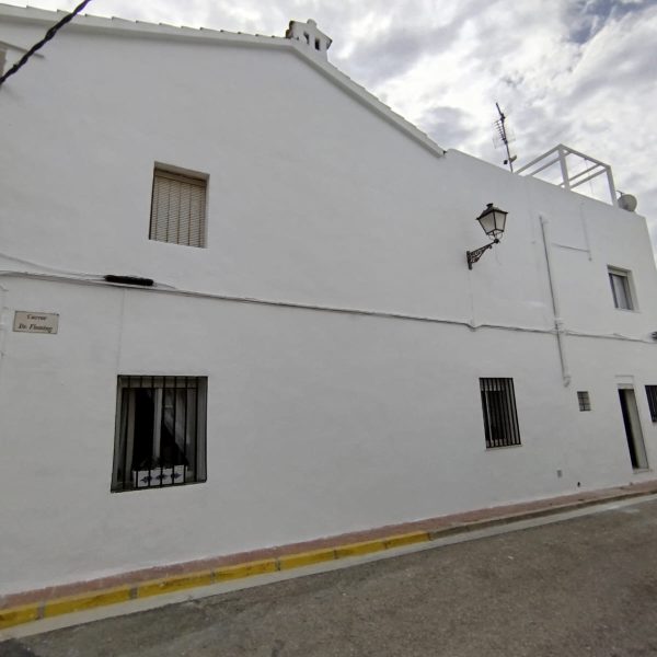 Fachada de una casa pintada de blanco en Valencia, con un acabado limpio y elegante que destaca en el entorno