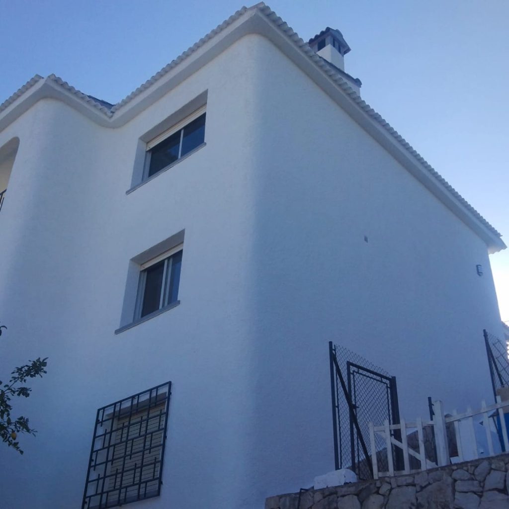 Fachada exterior de una casa pintada de blanco en Valencia, con un acabado limpio y elegante